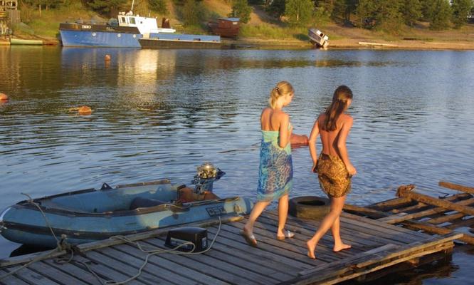 Chicas desnudas en el muelle del bote